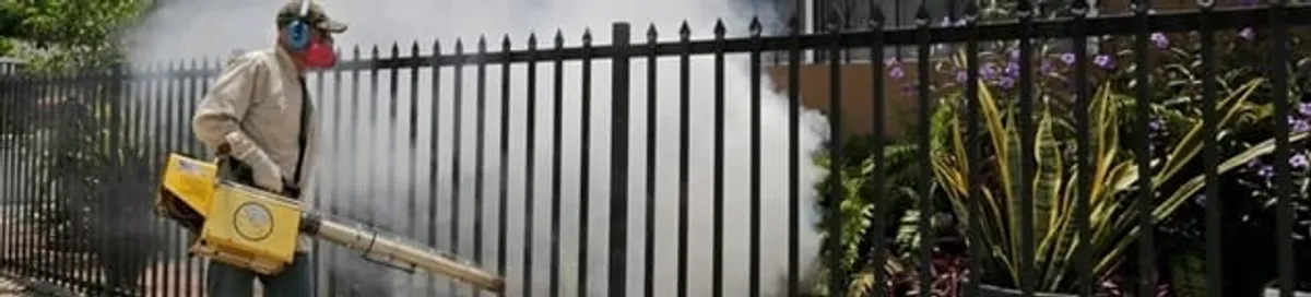 Mosquito control technician fogging a yard perimeter for mosquito reduction in Fort Collins, CO